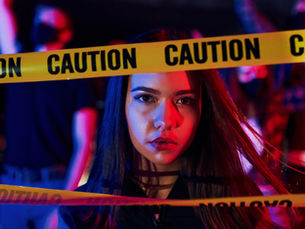  A woman stands behind a caution tape.