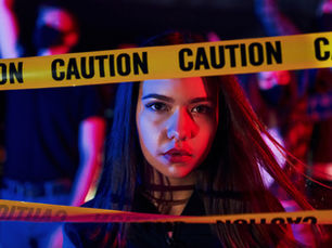  A woman stands behind a caution tape.