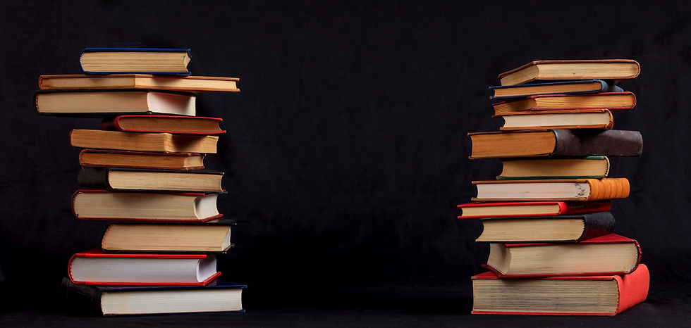 A picture of two equal-sized stacks of books side-by-side against a black background.