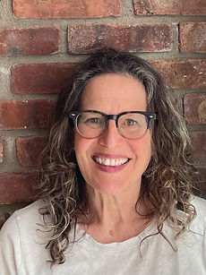An image of author Catherine Newman. A smiling woman in glasses with curly brown and gray shoulder-length hair.