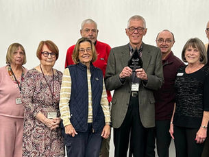 A group of people standing together and smiling - the Friends of RHPL at their annual meeting