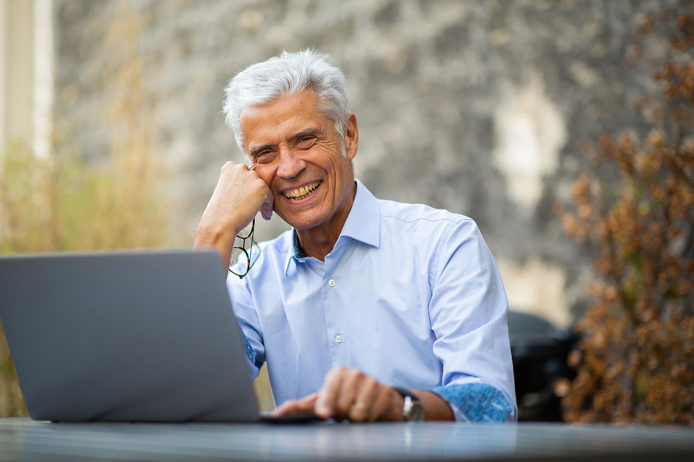  A smiling man works on a laptop