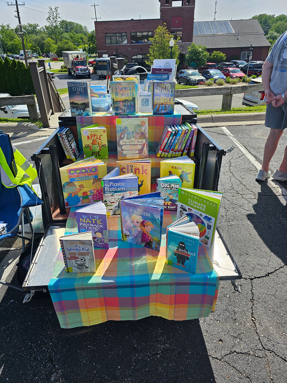 Books on a tiered display, arranged on a multi-colored checked cloth.