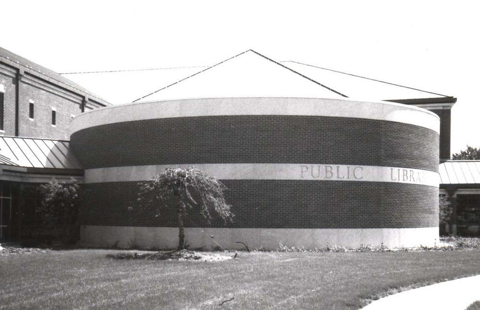 A black and white image of the front of the current library building, with a small elm tree 