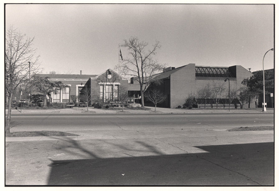 A black and white photo of the West University building with a expansion that added a large rectangular section with windows